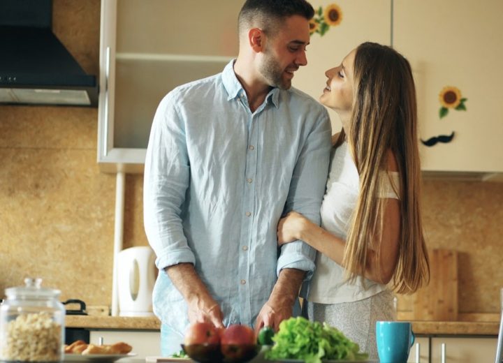 Portrait of loving couple cooking breakfast smiling in the kitchen at home